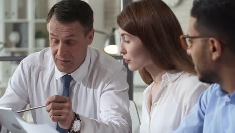 Senior-Entrepreneur-Using-Tablet-at-Meeting-with-Young-Employees