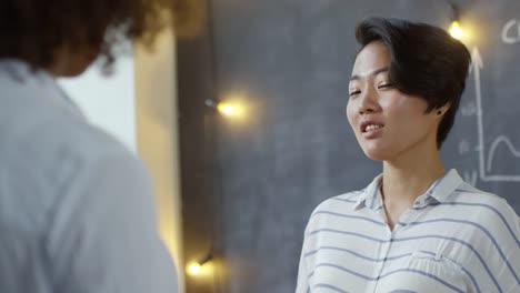 Young-Asian-Woman-Listening-to-Colleague