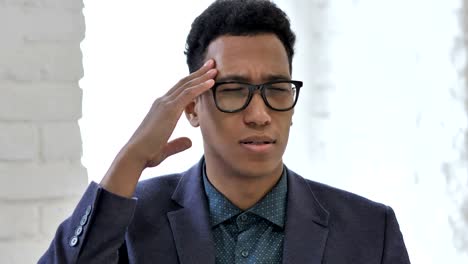 Close-up-of-Stressed-African-Businessman-with-Headache-Working-on-Laptop