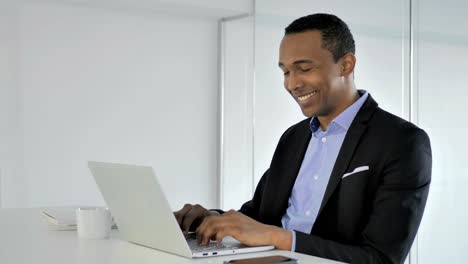 Casual-Afro-American-Businessman-Celebrating-Success,-Working-on-Laptop