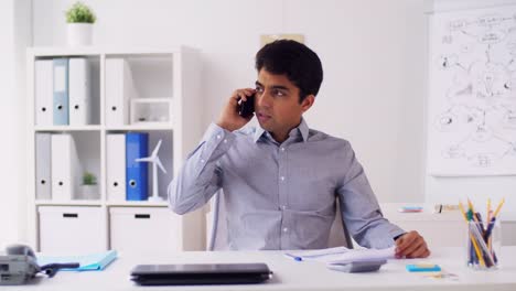 businessman-calling-on-smartphone-at-office