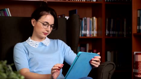 mujer-de-negocios-atractivo-joven-con-tablet-PC-fondo-de-estantería-de-oficina-librory