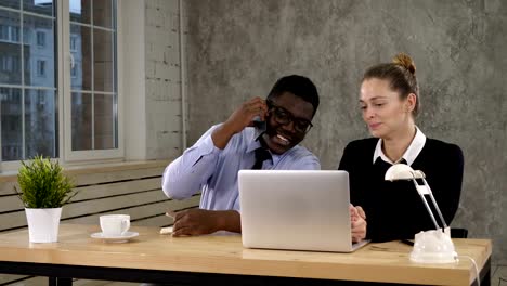 Businesswoman-Using-Laptop-And-Businessman-Making-Call-Team-work