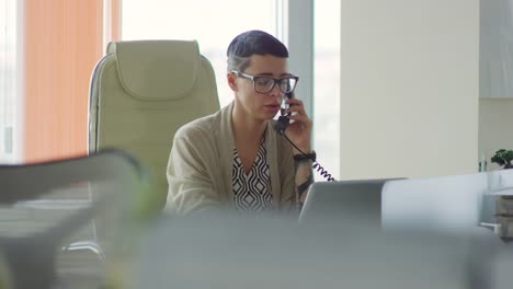 Businesswoman-Talking-on-Phone-and-Using-Laptop
