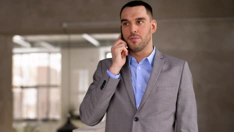 businessman-calling-on-smartphone-at-office