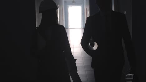 Silhouettes-of-Architects-Going-Together-along-Hallway