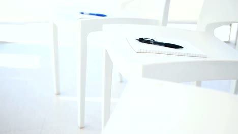 Notebook-with-pen-on-white-chair