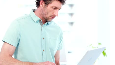 Smiling-businessman-using-a-laptop