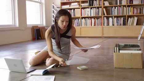 Businesswoman-Laying-Out-Documents-On-Floor-Shot-On-R3D