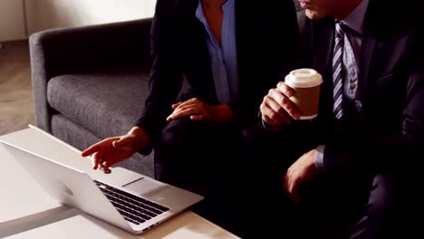 Serious-business-people-working-together-while-looking-laptop