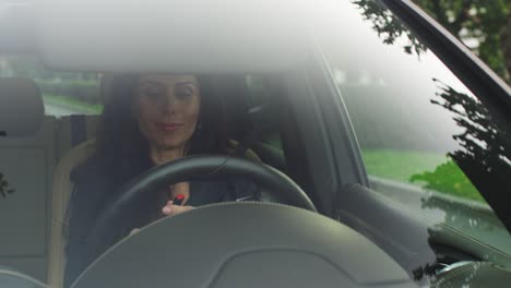 Attractive-Smiling-Business-Woman-Applying-Makeup-in-a-Car