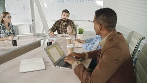 Bearded-businessman-conducting-meeting-with-business-people