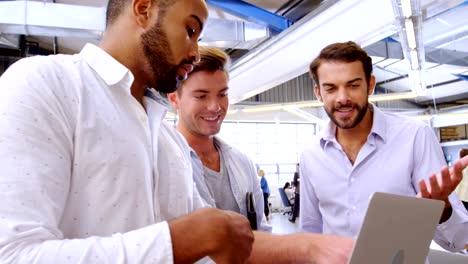 Business-executives-discussing-over-laptop