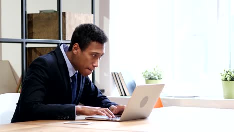 Black-Businessman-Celebrating-Success-while-Working-on-Laptop