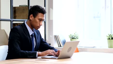 Black-Man-Smiling-at-Work,-Looking-toward-Camera