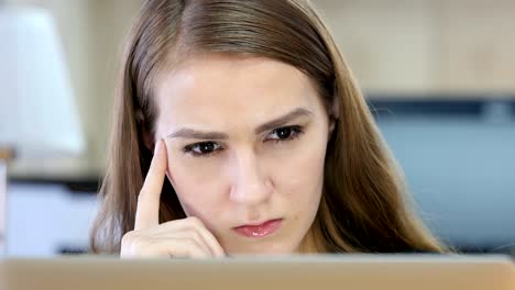 Woman-Thinking-and-Working-on-Laptop