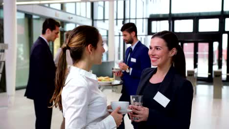 Smiling-businesspeople-interacting-with-each-other-during-break