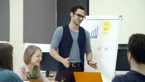 Man-speaking-to-coworkers-during-presentation