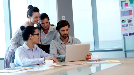 Business-colleagues-discussing-over-laptop