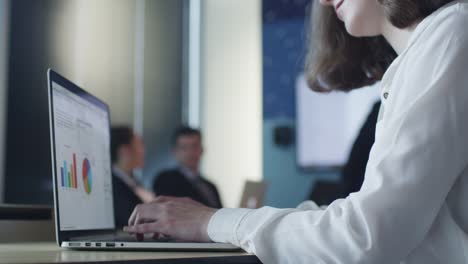 Businessman-working-on-Laptop-during-Presentation-in-Conference-Room