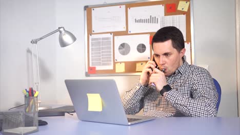 Young-businessman-is-vaping-e-sigaret-while-talking-on-the-phone.