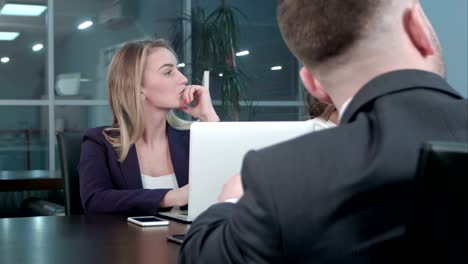 Young-blond-businesswoman-working-communicate-with-colleagues-at-conference-in-the-office