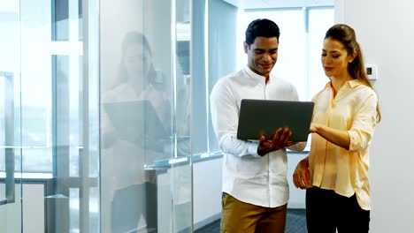 Business-colleagues-discussing-over-laptop