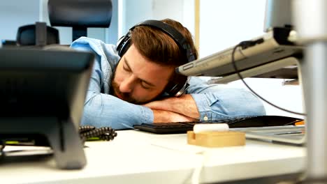 Male-graphic-designer-sleeping-at-desk