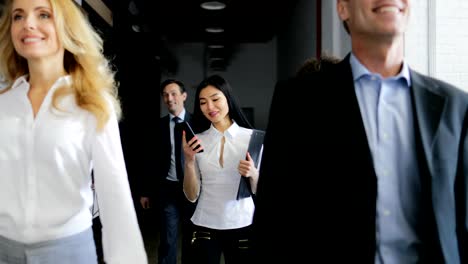 Team-Of-Business-People-Walking-In-Office-While-Asian-Businesswoman-Answer-Phone-Call