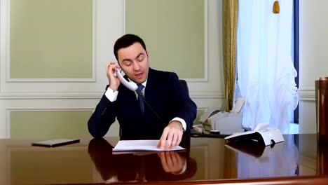 Angry-businessman-has-a-heated-conversation-with-someone-on-landline-phone