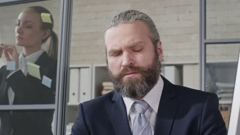 Businessman-Thinking-Hard-and-Typing-on-Computer