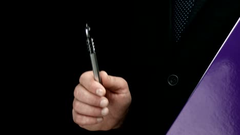 Businessman-Holding-A-Purple-Folder-Performs-Gestures-With-A-Pen.