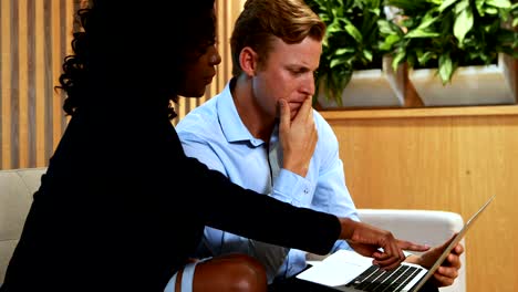 Businesswoman-and-colleague-discussing-over-laptop