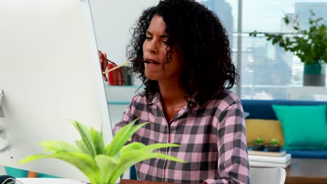 Thoughtful-female-executive-working-on-computer-at-desk-4k