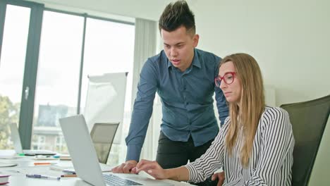 Zwei-Menschen-diskutieren-Ideen-mit-Laptop