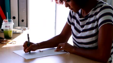 Ejecutivo-mujer-escribiendo-en-un-papel-en-su-escritorio-4k