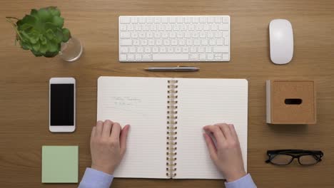 Overhead-Top-View-Of-woman-Reading-Reminder-Written-In-Diary