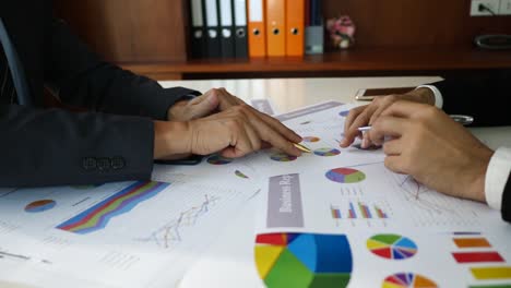 Businessman-examining-graphs-with-other-working-people.