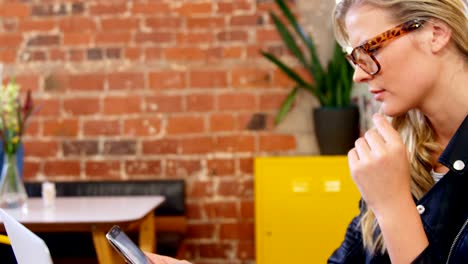 Beautiful-woman-using-mobile-phone-and-laptop-at-table-4k