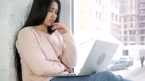 Nachdenkliche-junge-Afro-amerikanische-Frau-arbeiten-am-Laptop,-Blick-durch-Fenster