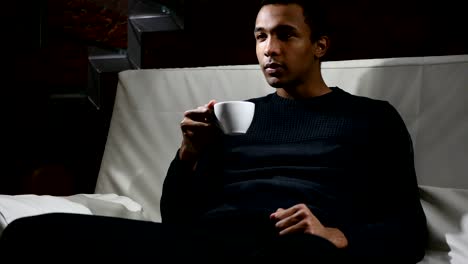 Pensive-African-Man-Drinking-Coffee-from-Cup,-Loft-interior