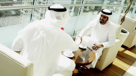 Emirates-businessmen-traditional-dress-handshake-downtown-city-office