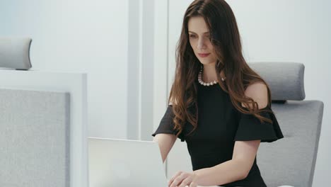 businesswoman-sitting-on-a-chair-and-works-on-the-computer