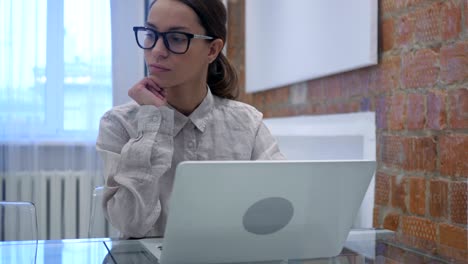 Pensamiento-de-mujer-hispana-trabajando-en-ordenador-portátil,-sentado-en-la-oficina