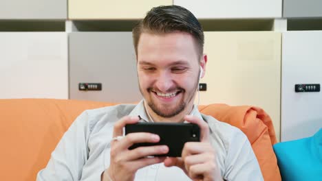 Man-Watching-Videos-on-the-Smartphone-Indoors