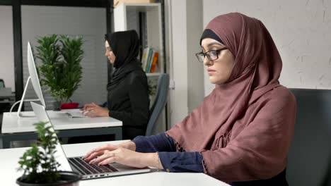 Una-joven-hermosa-en-hijab-rosa-saca-sus-gafas-y-masajes-el-puente-de-su-nariz.-Ojos-cansados.-Chicas-Arabes-en-la-oficina.-60-fps