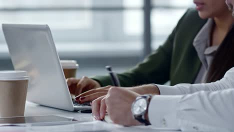 Hands-of-Office-Workers-Typing-on-Laptop-and-Writing-Notes