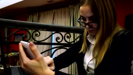 Business-lady-with-glasses-jacket-and-shirt-to-use-a-smartphone