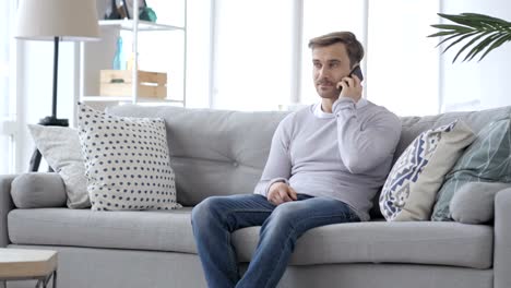 Adult-Man-Talking-on-Phone-while-Sitting-on-Couch