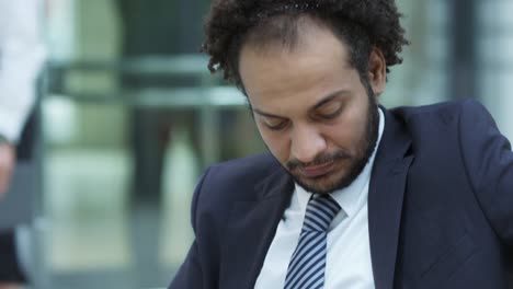 Businessman-Working-on-Tablet-in-Lobby-of-Office-Center